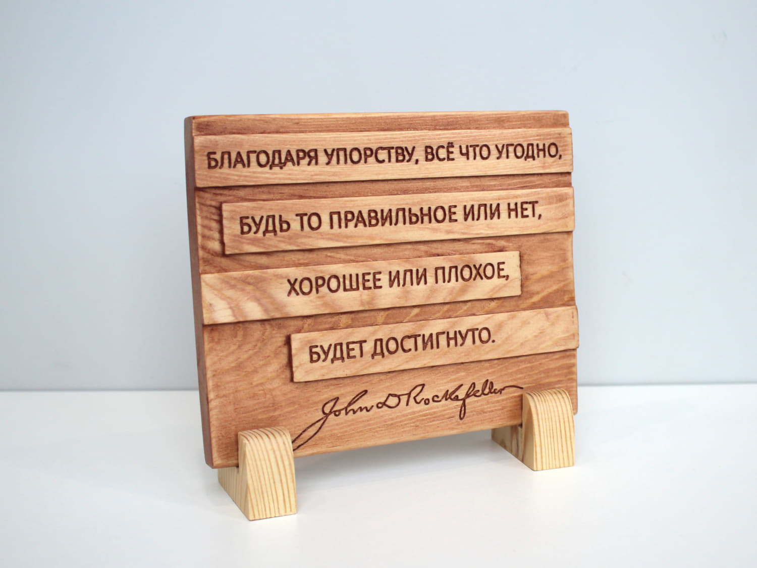 Табличка с цитатой Джона Рокфеллера «Благодаря упорству, все что угодно, будь то правильное или нет, хорошее или плохое, будет достигнуто»