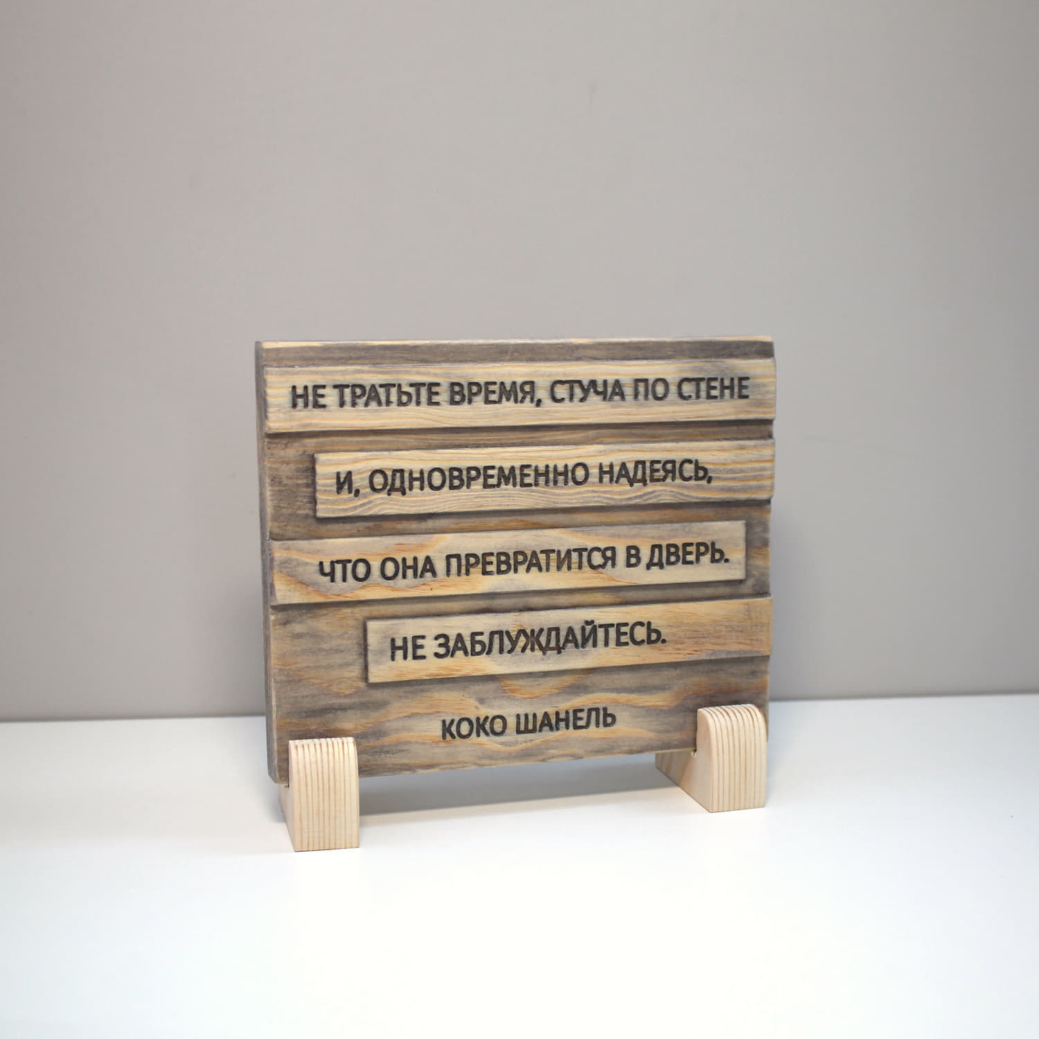 Табличка с цитатой Коко Шанель «Не тратьте время, стуча по стене и, одновременно надеясь, что она превратится в дверь. Не заблуждайтесь»